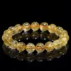 SCPGRU01E1 Natural Rutilated Quartz bracelet for Wealth & Success on black reflective background