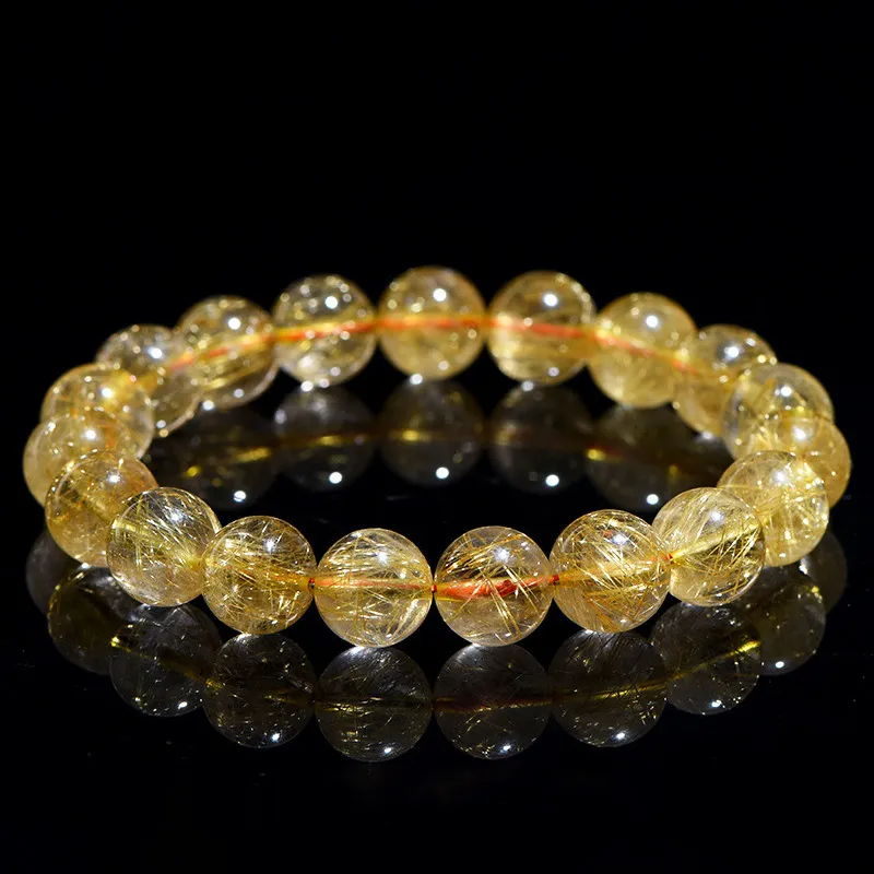 SCPGRU01E1 Natural Rutilated Quartz bracelet for Wealth & Success on black reflective background
