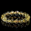 SCPGRU01P1 Natural Rutilated Quartz bracelet for Wealth & Success on black reflective background