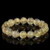 SCPGRU01S1 Natural Rutilated Quartz bracelet for Wealth & Success on black reflective background