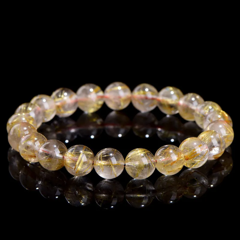 Natural Rutilated Quartz bracelet for Wealth & Success on black background