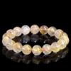 Natural Rutilated Quartz bracelet for Wealth & Success on black background