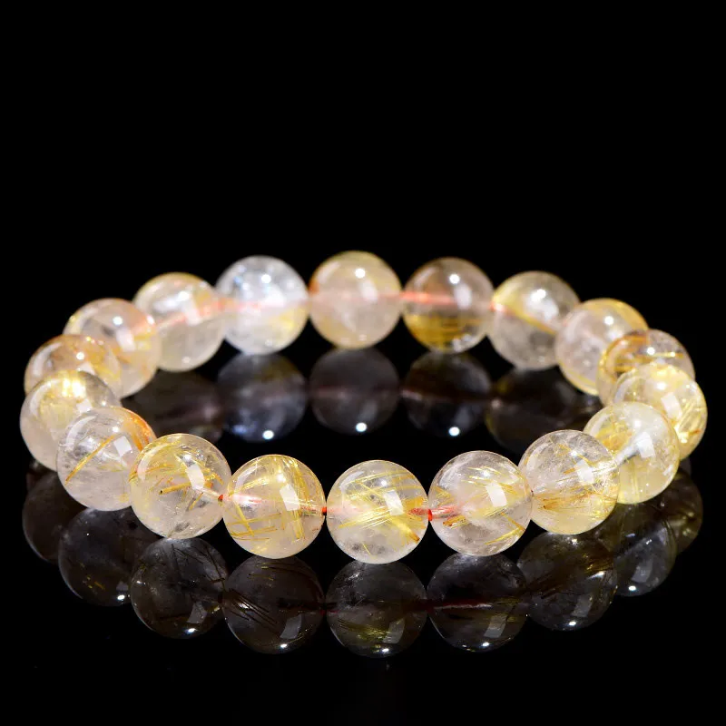 Natural Rutilated Quartz bracelet for Wealth & Success on black background