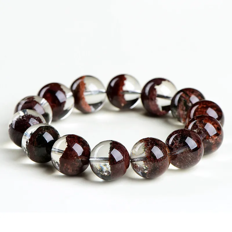 Natural Phantom Quartz bracelet for Wealth & Success featuring clear beads with deep reddish-brown mineral inclusions on white background