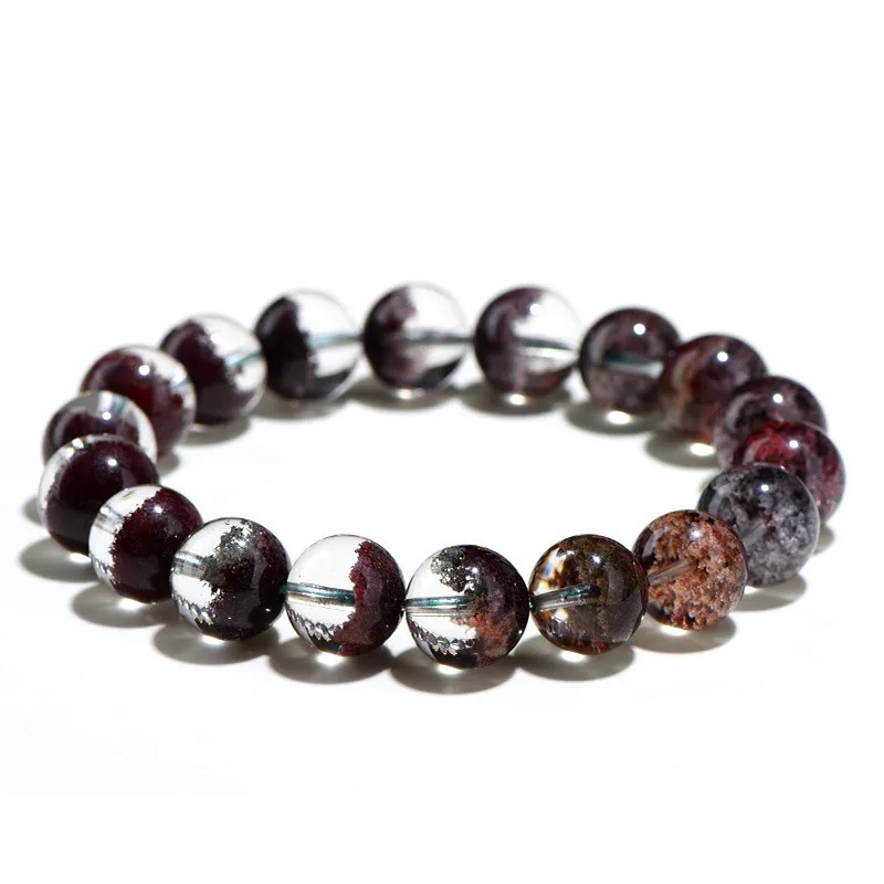 Natural Phantom Quartz bracelet for Wealth & Success featuring clear beads with deep reddish-brown mineral inclusions on white background