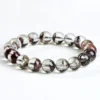 Natural Phantom Quartz bracelet for Wealth & Success featuring clear beads with deep reddish-brown mineral inclusions on white background