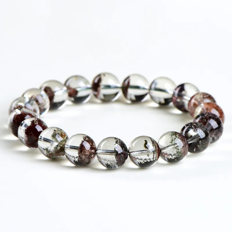 Natural Phantom Quartz bracelet for Wealth & Success featuring clear beads with deep reddish-brown mineral inclusions on white background